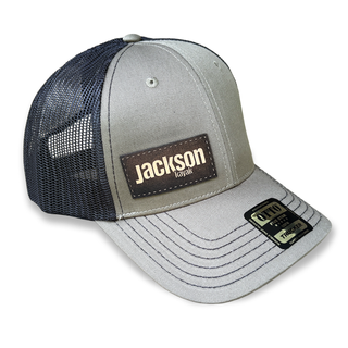 black mesh trucker hat with olive front and bill with dark brown jackson kayak leather patch logo, front