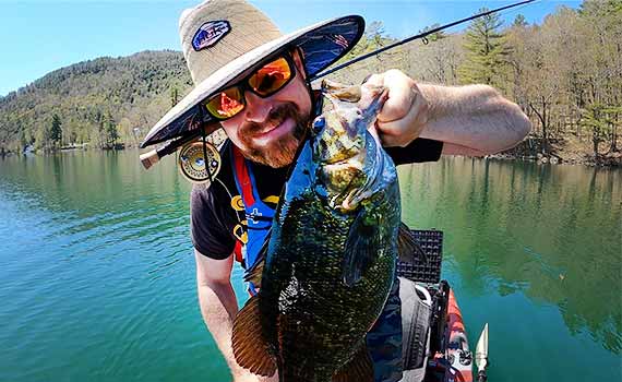 happy fly fisherman with large smallmouth bass
