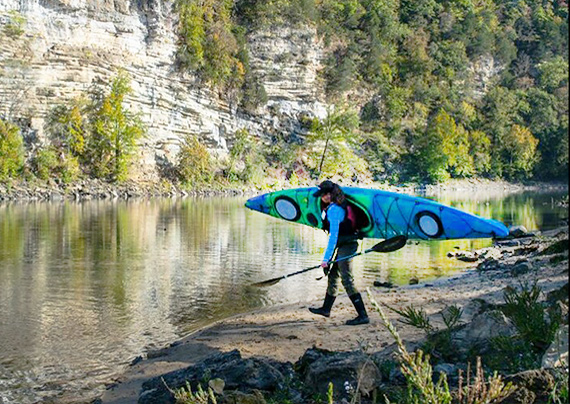Happy paddler at river launch in a Journey touring kayak