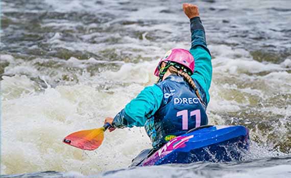 kayaker with arm raised in victory