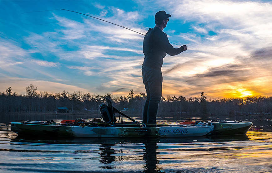 angler in a taketwo jackson kayak holding a fish with a bow-mounted motorguide trolling motor on the front
