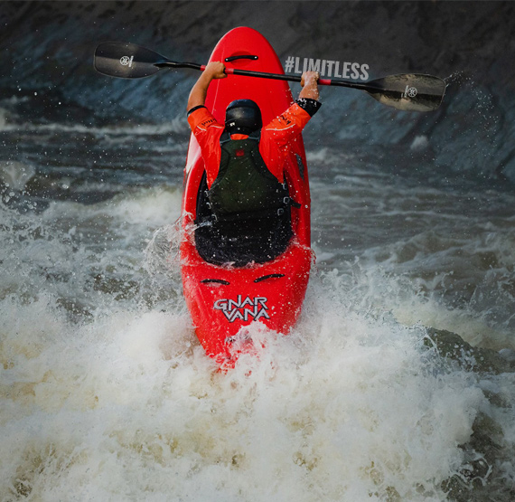 Person kayaking in a whitewater kayak.