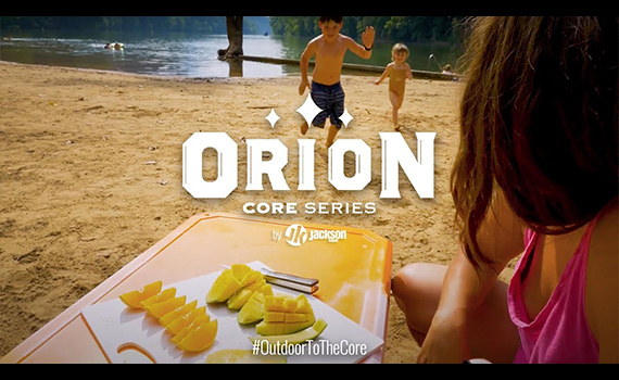 Family on the beach with food on an Orion Cooler.