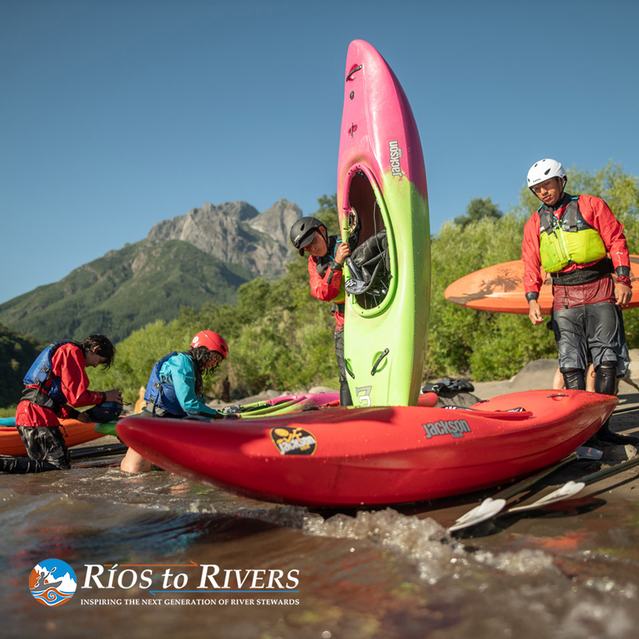 paddlers staging boats on shore in advance of an expedition - rios to rivers logo